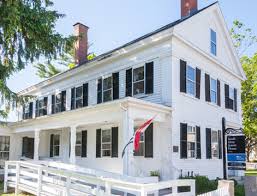 Natural light drenches the great room, which opens to the kitchen, with a massive island anchoring the living space. Architectural Style Guide Historic New England