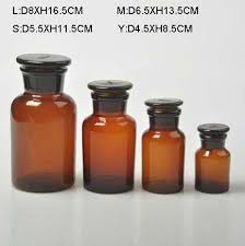 Herbal apothecary shelf with glass cork top bottles filled with dried herbs with hanging dried plants below. Wholesale Glass Apothecary Jars And Vintage Amber Brown Glass Apothecary Jar Buy Wholesale Glass Apothecary Jars Glass Apothecary Jars Brown Glass Apothecary Jar Product On Alibaba Com