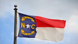 Indoor and parade north carolina state flags adopted as the official state flag of north carolina in 1885, this red, white and blue flag features the letters nc for the state's name along with a white star, and two yellow scrolls inscribed with dates. State Of Nc Flag History Raltoday