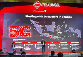 Seorang wanita mengoperasikan ponselnya di dekat logo teknologi 5g. 5g Internet 5g Telkomsel Sudah Bisa Dicoba Ini Harga Paket Data Dan Lokasi Layanan