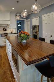 Here, the white island offers a clean and subtle departure from wood cabinets and paneled walls. Sapele Mahogany Kitchen Island Top Designed By Drury Design Kitchen Bath Studio Wood Countertop Butcherblock And Bar Top Blog