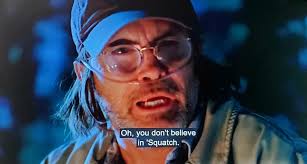 What movie features a scene where a woman is folded in half and ripped out  a small window by a sasquatch?