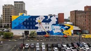 Wallsauce is an online, wall mural and photo wallpaper company providing bespoke print on demand wallpaper and wall murals to uk and international customers. Artists Painting Mural On Side Of Onsd Building In Downtown Evansville