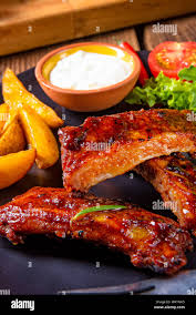 Costillas A La Barbacoa En La Plancha Con Ensalada Verde Y Salsa Blanca Fotografia De Stock Alamy