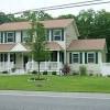 Green mcmansion with green exterior shutters. 1