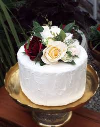 When considering wedding cake flowers it's important to remember that the flowers are there to garnish your wedding cake. This Floral Cake Topper Is Created With Burgundy Pink Peach Cream And White Faux Artificial Flower Cake Toppers Floral Cake Topper Wedding Cakes With Flowers