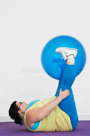 Overweight Woman Holding Up Exercise Ball With Legs Stock Image ...