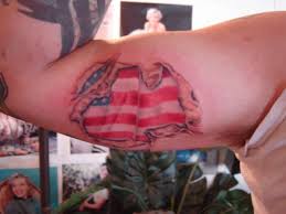 Tattoos are invented not just to show rebellion and guts but more importantly, it provides a human a place where he/she can carry something that makes him/her proud. Ripped Skin American Flag Tattoo On Bicep