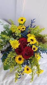 This has purple disbuds, purple mini carnations, yellow solidago, white roses, and pink heather.the funky part is the wire. Country Style Roses By Specialty Floral Design