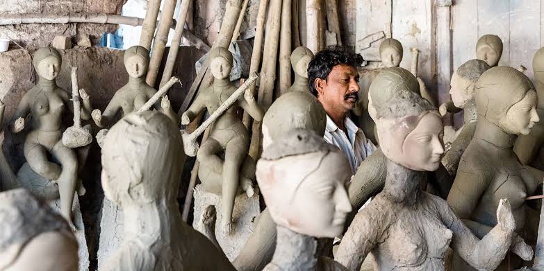 Artisans shaping clay idols in Kumartuli, AI generated