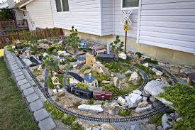 Garden trains run outside, surrounded by real miniature trees and water features. Garden Railroading 0040 Garden Railroad Garden Trains Garden Railway