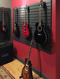 Hanging instruments on a wall is a great way to save space and show off your collection at the same time. Guitar Hanging System Used In Home For Guitar Storage And Display Guitar Display Guitar Storage Guitar Wall