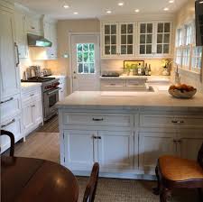 Small Southampton Kitchen Lives Large Glass Fronts Large Scale Hardware On Paneled Refrigerator Cabinetry A Bungalow Kitchen Kitchen Design Kitchen Remodel