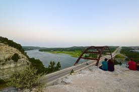 A rainbow overlooks the 360 bridge (pennybacker bridge) surrounding hills and lake austin aerial view from a helicopter of the 360 bridge (pennybacker bridge) overlooking lake austin. 360 Overlook At The Pennybacker Bridge Undeniably Austin
