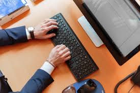 A man uses a computer mouse while working on a personal computer. Person Typing On Computer Keyboard 2058128 The Pie News