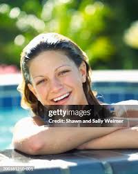 Teenage Girl Leaning On Edge Of Swimming Pool Portrait High-Res Stock Photo 
