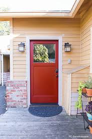 A simple wooden front door on an arched inset wall illuminated by outdoor sconces. Front Door Design Gallery Front Door Ideas Simpson Doors