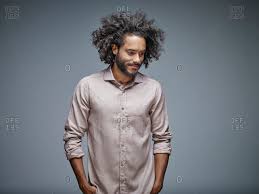 Hey everyone, this video shows the whole process of how you can get grey/ silver ash highlights on black hair. Portrait Of Smiling Young Man With Curly Brown Hair In Front Of Grey Background Stock Photo Offset