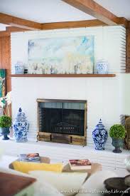 Mix up the paint with a stir stick, then dip in a large, flat artist's brush and start to paint! How To Paint A Brick Fireplace