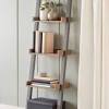 The ladder has shallow shelves at the top and deeper shelves at the bottom, and it leans and secures to the wall. 1