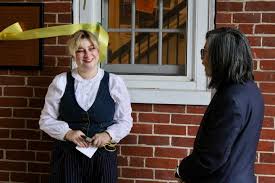 Haynes House President Sophia Mustone '26, along with Vice President for  Equity and Inclusion Floyd Cheung, cut a ceremonial ribbon to honor a new  plaque