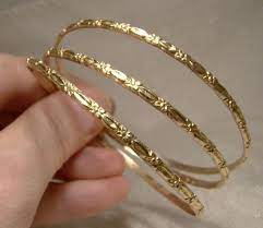 This fabulous bangle bracelet for her features a textured pattern that helps catch the light and adds intrigue to the simplistic design. 3 10k Yellow Gold Bangle Bracelets With Floral Motif Item 1383471