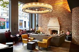 The fireplace in this room is tucked in the corner, with the brickwork popping out into the room a bit, creating an additional slanted wall within the space. 10 Beautiful Hotel Fireplaces For Fall Travel Vogue