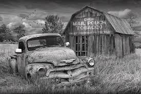 Add a contemporary focal point to any arrangement with this graphic art print. Black And White Of Rusted Chevy Pickup Truck In A Rural Landscape By A Mail Pouch Tobacco Barn Photograph By Randall Nyhof
