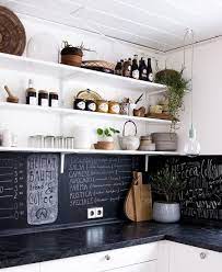 This chalkboard paint backsplash is perfect for any kitchen. A Black Chalkboard Backsplash And Black Marble Countertops In A White Kitchen Nebolshie Kuhni Kuhnya V Morskom Stile Kvartira Kuhnya