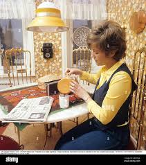 Coffee in the 1970s. Singer Anna-Lena Löfgren, 1944-2010, pictured at home  having a cup of coffee. The color picture shows the decades typical  patterns of the wallpaper and the table cloth. She
