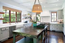 A tiny green kitchen island on casters with drawers and holders plus a stone countertop. The Forest Green Kitchen Island Gives The Space A Pop Of Color Tour The House Reese Witherspoon Just Sold For 10 Million Popsugar Home Photo 9