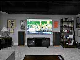 The center of this basement man cave showcases a stone base custom bar. Basement Man Cave Basement Finishing Matrix Basement Systems