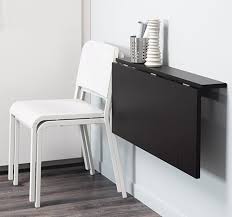 Ett Svart Vagghangt Klaffbord Med Tva Vita Stolar Staplade Bredvid Wall Mounted Table Wall Table
