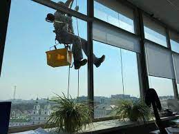 grimpeur nettoyer les fenêtres de l'extérieur du bâtiment en lavant le  vitrage de la façade d'un immeuble à plusieurs étages 14748936 Photo de  stock chez Vecteezy