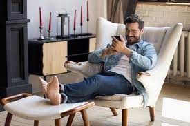 Gut Aussehender Mann Mit Smartphone Entspannt Auf Bequemen Sessel Stockfoto  - Bild von einzeln, luxus: 224217060