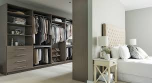 Bedroom with walk in closet behind bed. Optimising Bedroom Space With Integrated Wardrobes Designbuild