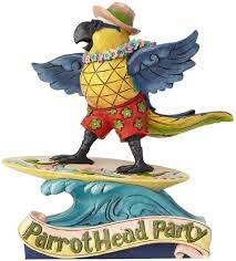 This jim shore bird leans against a palm tree wearing a straw hat, with a drink and beautiful feather engravings across his chest. Amazon Com Enesco Margaritaville By Jim Shore Margaritaville Surfing Parrot Home Kitchen