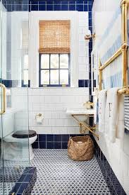 Navy blue fish tile, ocean tile feature wall, fish decor, pattern ceramic tiles, dramatic back splash, unique aquarium tiles, bathtub tiles. White And Navy Blue Bathroom With Brass Towel Warmer Transitional Bathroom