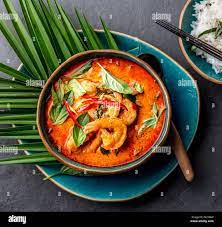 Crevettes au curry rouge thaï. Thaïlande tradition potage au curry rouge de crevettes Crevettes et lait de coco. Curry Panaeng en plaque bleue sur fond gris Photo Stock - Alamy