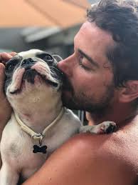 Hombre abrazando a un bulldog francés blanco y negro