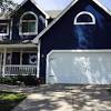 A large brick traditional house completed with a sherwin williams dark moody blue front door 1