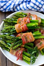 A Plate Of Bacon Wrapped Asparagus Bundles Garnished With Parsley Bacon Wrapped Asparagus Recipes Asparagus Recipe Asparagus Bacon