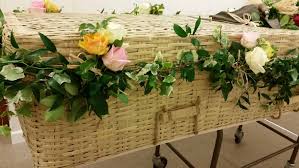 231 0.00 the village florist. Wicker Coffin Garland With Roses Wild Daisy Florist