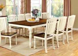 Lake house dining room with wide plank oak flooring, white board and batten walls and rustic table and grey dining chairs. August Grove Andrew 42 Dining Table Wayfair