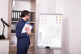 businessman with a folder with charts in hands next to a flip chart