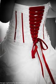 The Back Of A Brides Wedding Dress With Red Lace Up Detail And A Corset Ribbon Photographed By Red Wedding Dresses Wedding Dresses Lace White Wedding Dresses