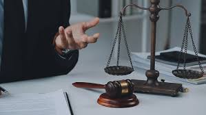 Justice and Law concept. Legal counsel presents to the client a signed  contract with gavel and legal law or legal having team meeting at law firm  in background