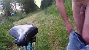 Nackter Radfahrer auf einer Forststraße