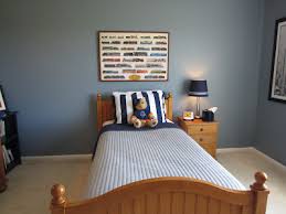 Rustic boy's room with dark navy walls and wood accents. Remodelaholic Blue Boys Bedroom Makeover With Chevron Curtains