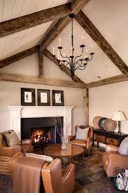 Inspiration for a large country open concept family room in chicago with white walls, medium hardwood floors, a standard fireplace, a stone fireplace surround, brown floor, exposed beam and planked wall panelling. Wood Beams Farm House Living Room Rustic Living Room Design Beams Living Room